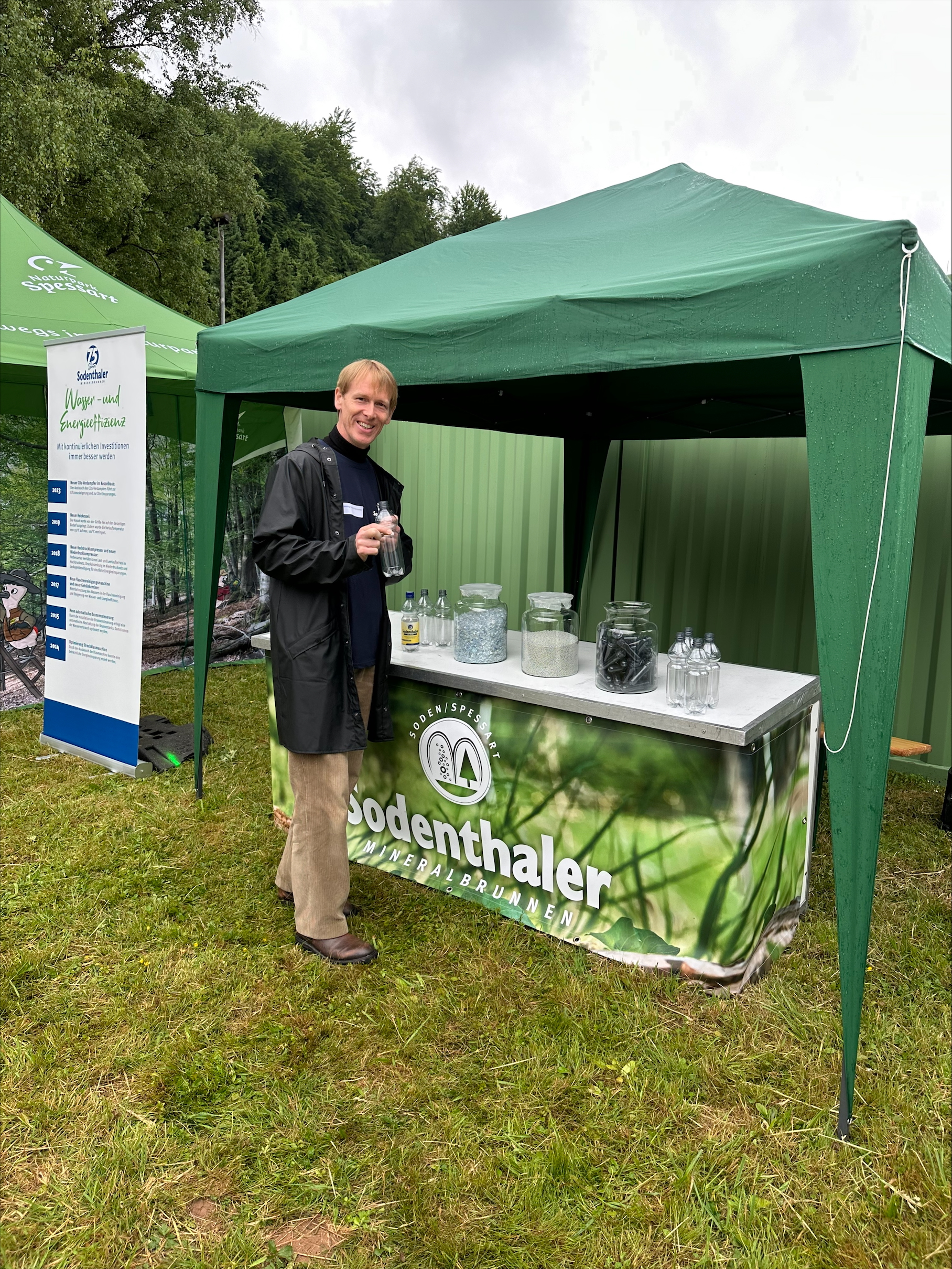 Ein Mitarbeiter präsentiert Informationen über Mineralwasser an einem Sodenthaler-Stand unter einem Pavillon.